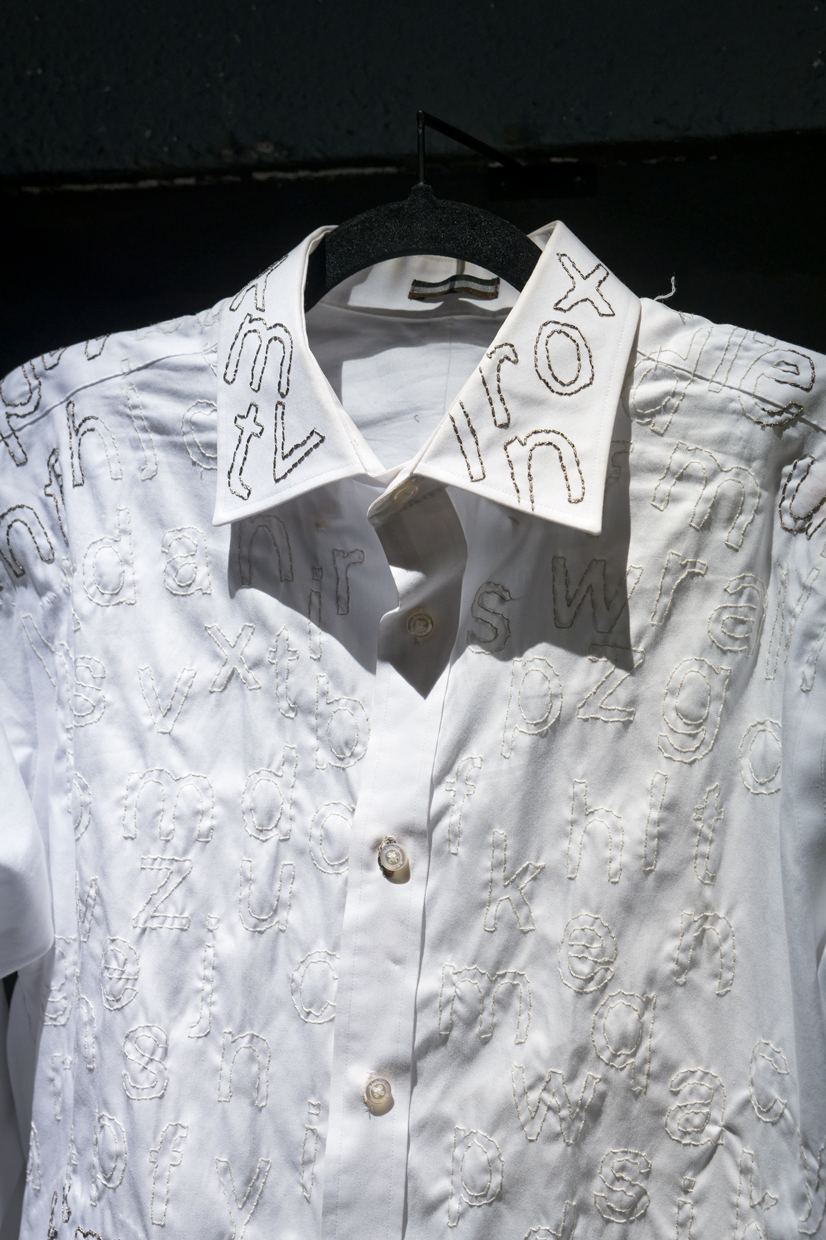 Zoom sur le col d'une chemise blanche brodée