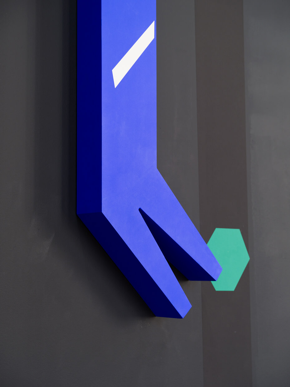 A blue vertical panel with a white diagonal stripe is partially visible between gray surfaces; the bottom of the image is obscured by a black area.