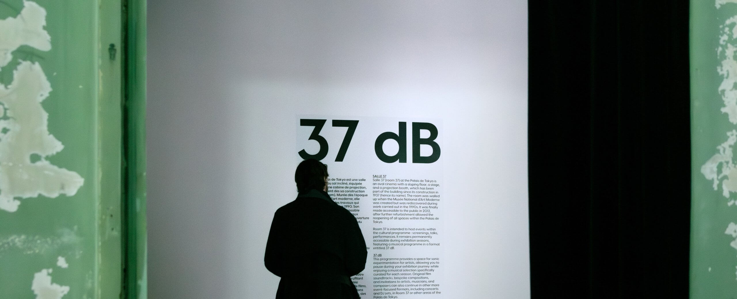 Une personne se trouve devant un écran mural sur lequel est écrit 37 dB en gros caractères, avec un paragraphe explicatif en dessous.