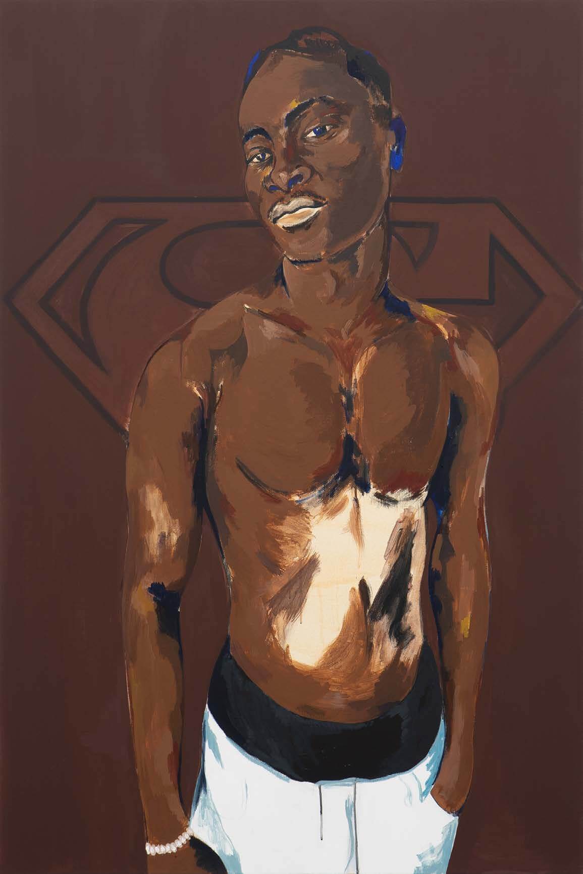 Un homme torse nu portant un pantalon de couleur claire se tient devant un fond marron sur lequel figure un léger logo de Superman.