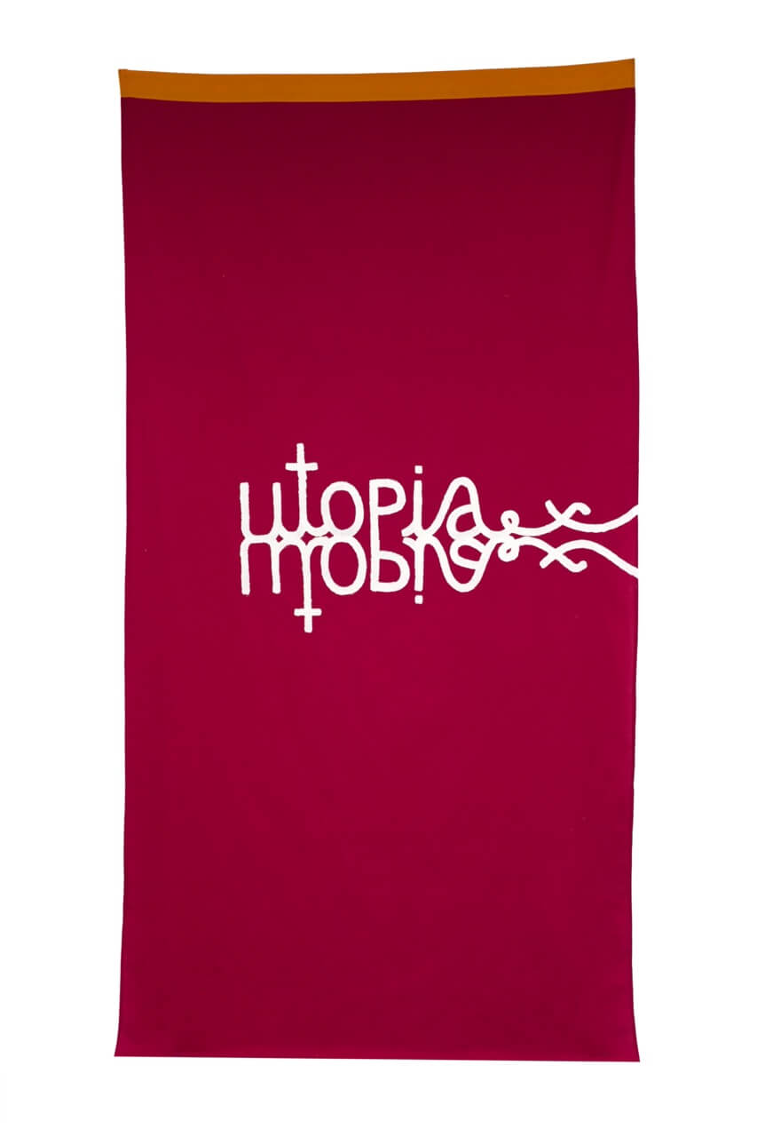 Un tissu rectangulaire rouge avec "utopia" écrit en blanc, reflété verticalement, avec une bordure orange le long du bord supérieur.